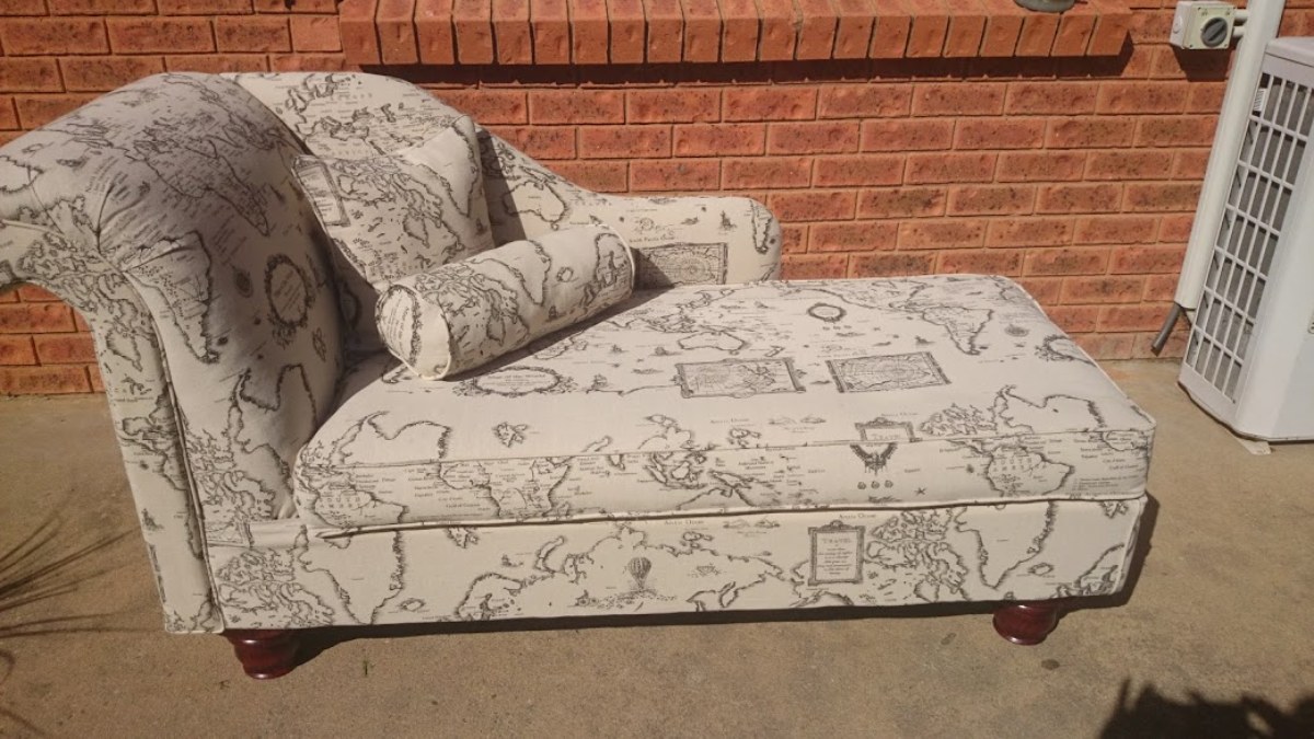 Cream Chaise lounge with world map themed fabric.