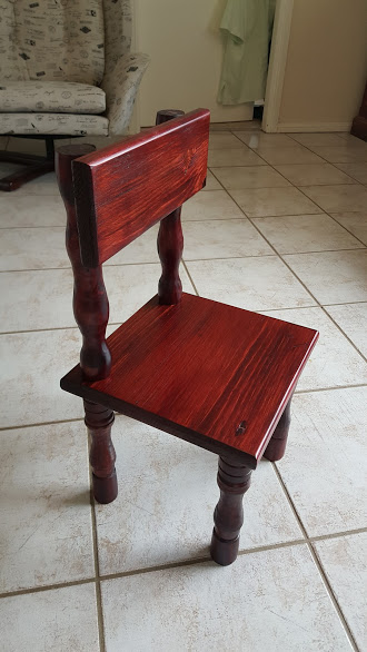 Applying dark mahogany stain to the toddler chair wood
