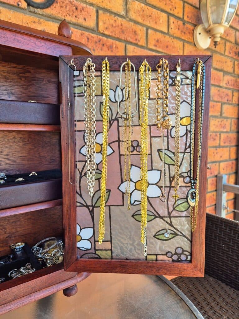 stained glass window showing are to hang necklaces.