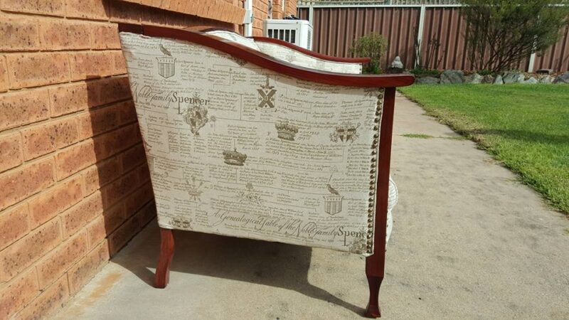 Restored vintage couch with wooden arms and Spenser family genealogy print fabric- side view showing studs.
