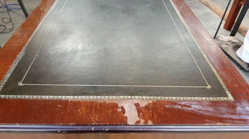 Thick cracked varnish surface on leather top desk.