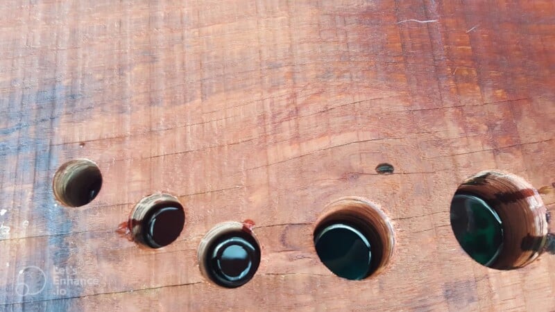 back view of shallow resin poured into holes in wood