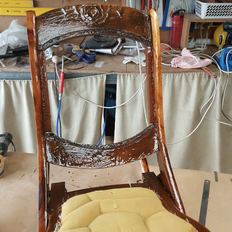 Scraping varnish from chair legs using Citri-Strip