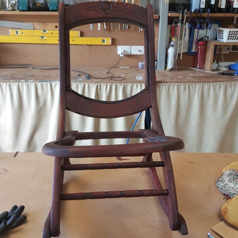 Applying dark mahogany wood stain to chair frame