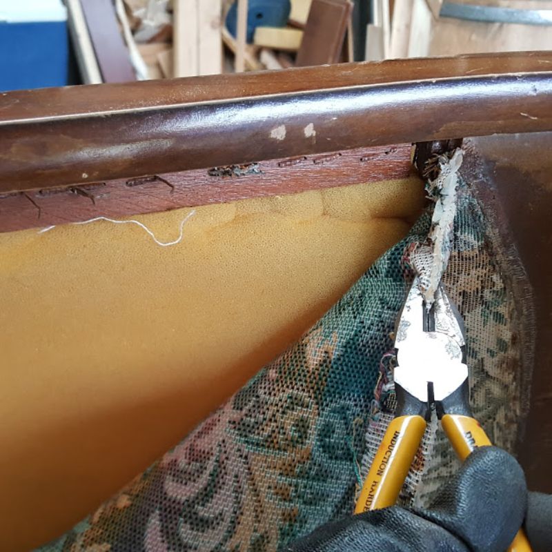 Removing old staples and trim from the backrest