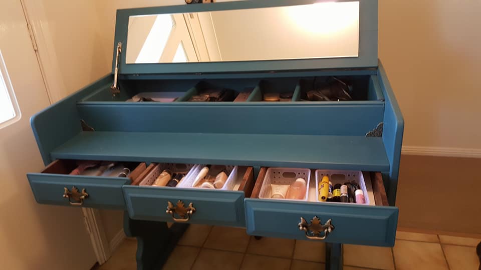 Old desk repurposed into a beauty bar for beauty storage. 