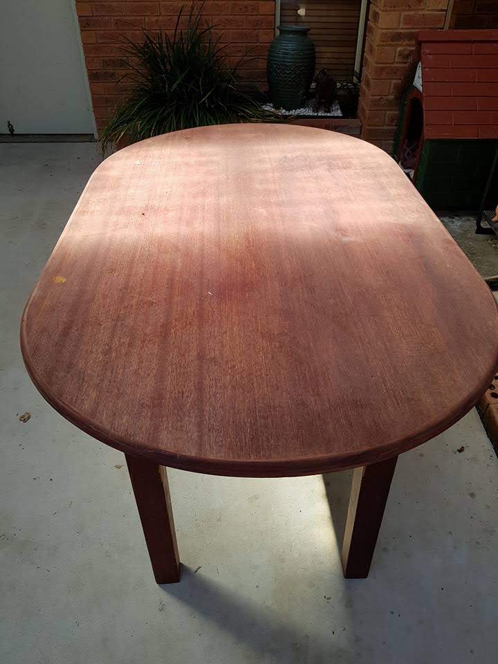 Old table with damaged veneer and missing drawer