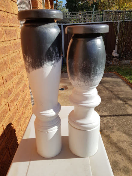 Finished candlesticks with rustic black and white dry brushed paint, ready for display.