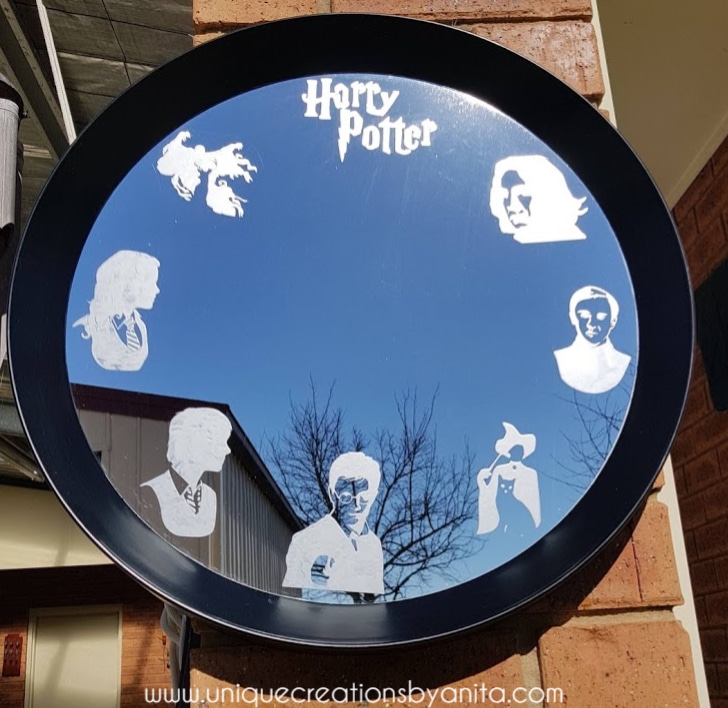 harry potter mirror with etched characters on surface