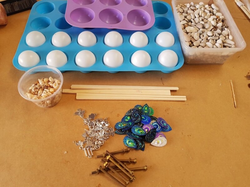 Ping pong balls sitting in silicone mould and items to be used embedded in the resin. 