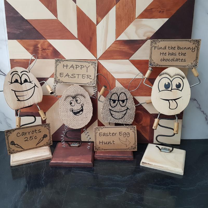 all four wooded easter eggs posing together with signs