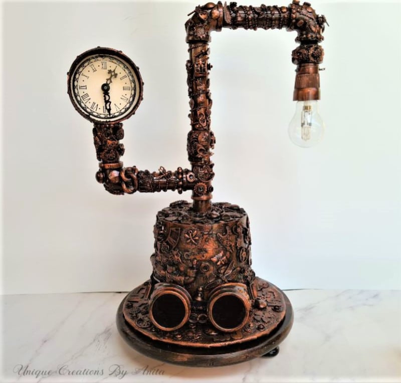 Decorated Steampunk lamp made from plumbing pipes with a hat as a base and a clock.