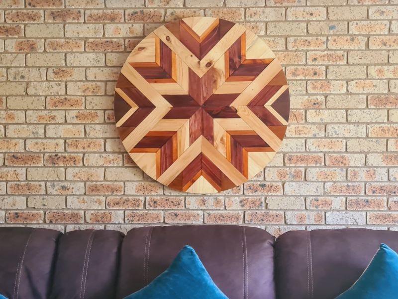 Round barn quilt hanging on lounge brick wall