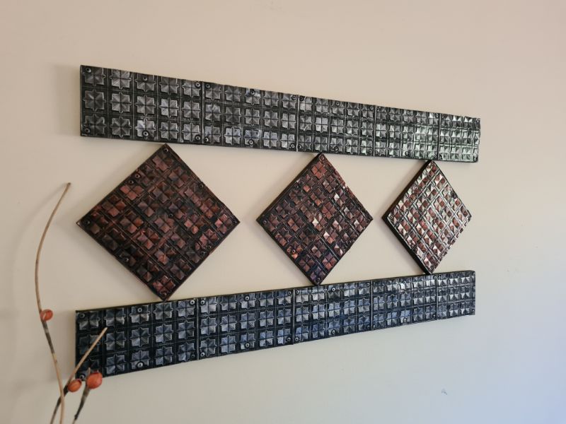 Completed aluminium can wall hanging displayed on living room wall- side view