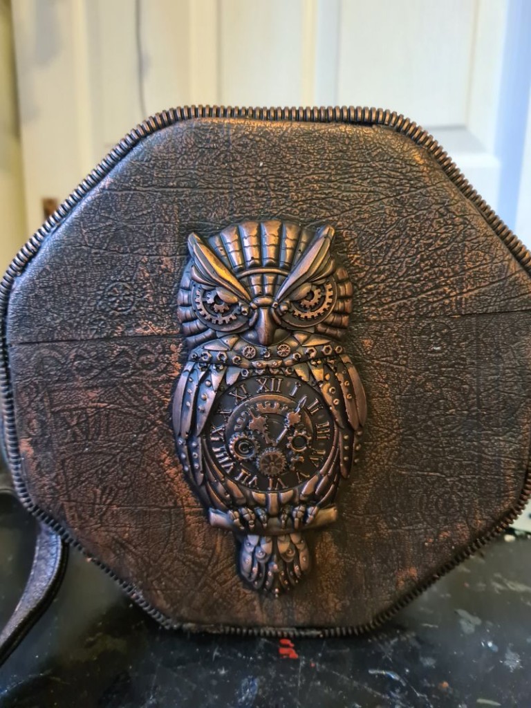 Copper wax rubbed on raised textures to highlight details - front