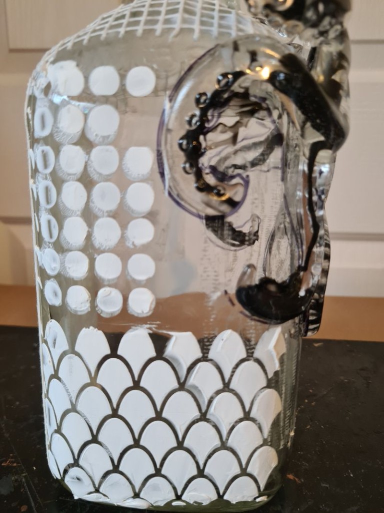 Close-up of dried, raised stencil pattern creating subtle texture on glass