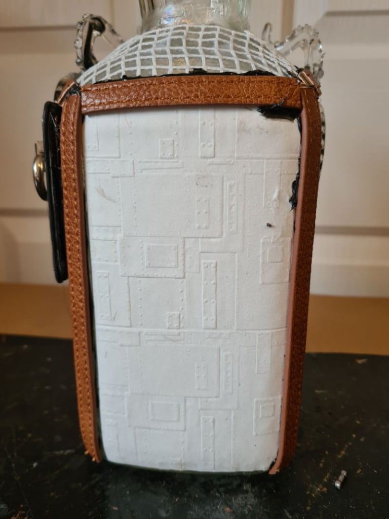 Salvaged belts added  bottle assemblage.