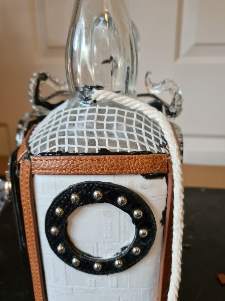 Rope wrapped tightly around bottle neck and secured with black hot glue for grip.