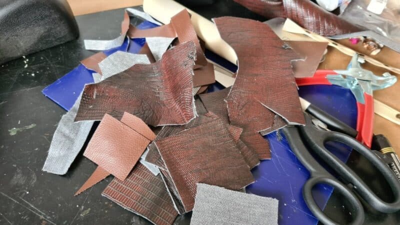 cut scraps of leather into squares 