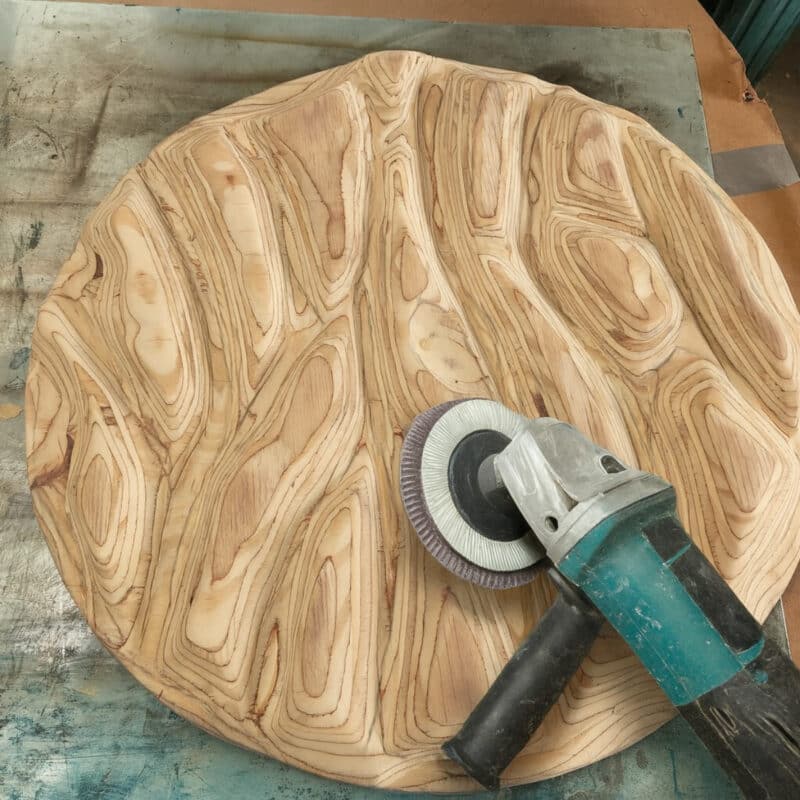 using a grinder with sanding disc to remove the bulk of wood