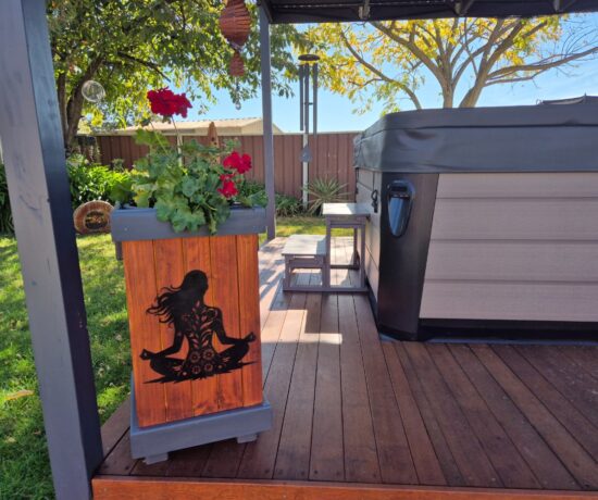 Red geranium in rustic wooden planter on spa deck