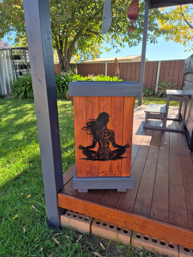 Wooden bin turned into outdoor planter on decking